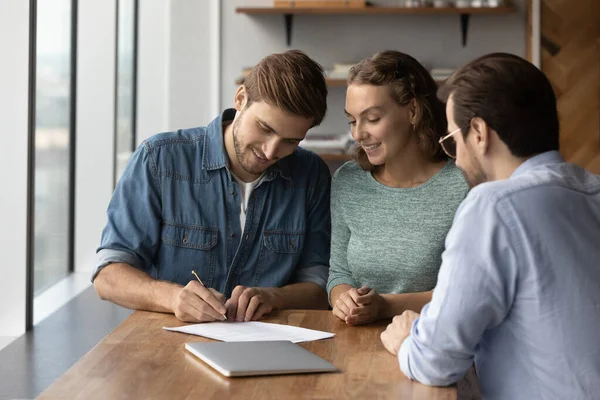 Happy young family couple client signing insurance document. — Stock Photo, Image