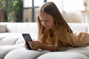 Modern teknoloji bağımlısı küçük kız mobil oyunlar oynuyor..