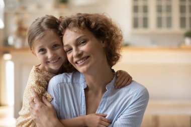 Samimi küçük kız, genç anneye sarılıyor..