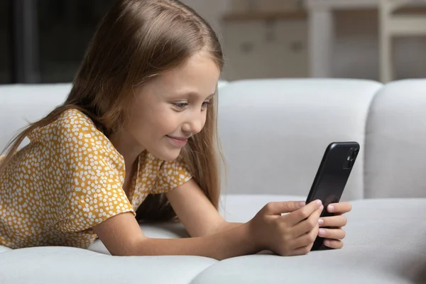 Addicted to modern tech sincere small girl playing mobile games. — Stock Photo, Image