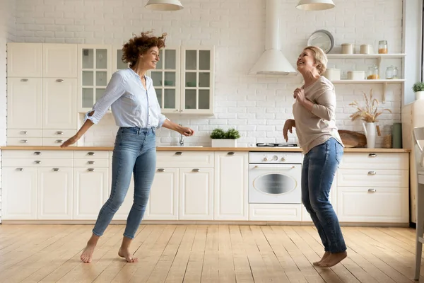 Gelukkig vrouw familie dansen samen in moderne keuken. — Stockfoto