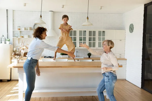 Щаслива сім'я трьох поколінь танцює разом на кухні . — стокове фото
