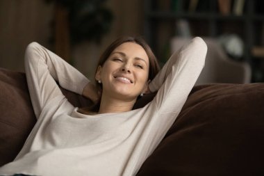 Gülümseyen çekici milenyum kadını rahat koltukta dinleniyor..