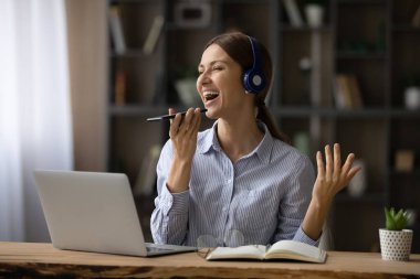 Mobil uygulamayla şarkı söyleyen mutlu duygusal genç kadın..