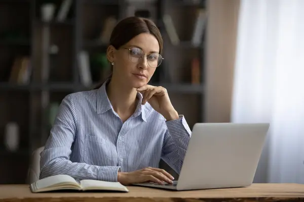 Porträtt av glad ung 30-tals affärskvinna i glasögon poserar i ämbetet. — Stockfoto