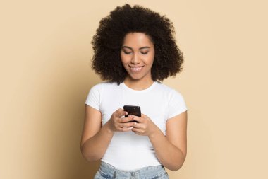 Gülümseyen Afrikalı Amerikalı kadın internetten cep telefonu mesajı kullanıyor