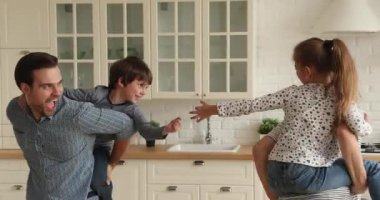 Mutlu genç ebeveynler küçük çocuklarla aktif oyun oynuyorlar..