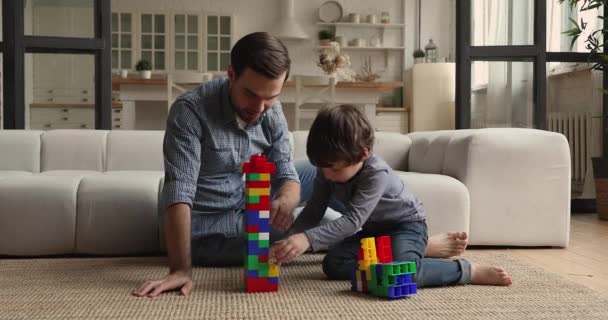 Caring young father playing toys with little kid son. — Stock video