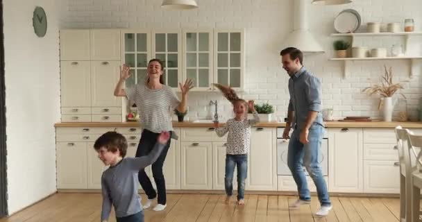 Щаслива молода пара танцює диско з маленькими дітьми . — стокове відео