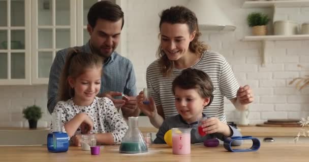 Joyful small children doing chemical experiments with parents. — стоковое видео