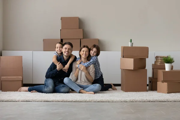 Retrato de familia feliz con niños relajarse en el día de mudanza — Foto de Stock