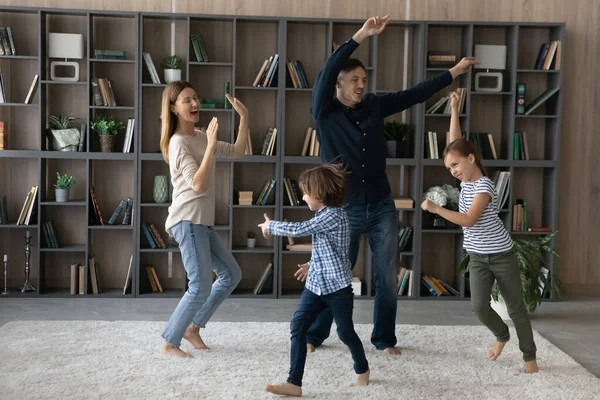 Boldog szülők gyerekekkel táncolnak együtt otthon. — Stock Fotó