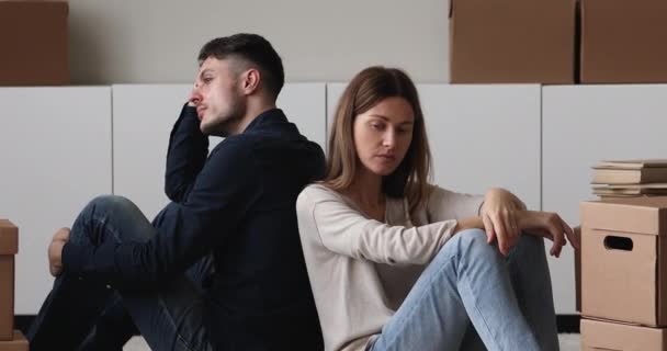 悲しいカップルは家を出る段ボール箱の近くの床に座る — ストック動画