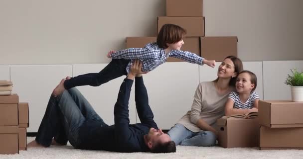 Familjen vilar leker på omlokaliseringsdagen i rummet med lådor — Stockvideo