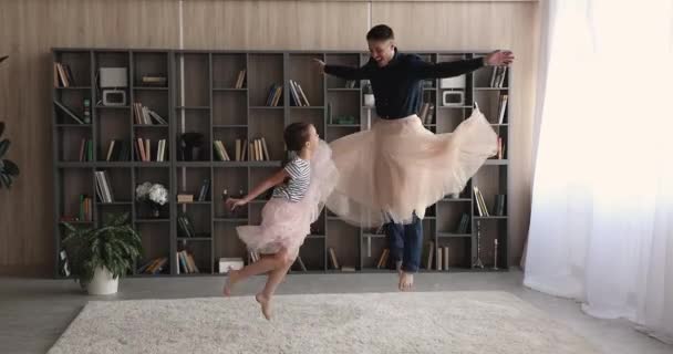 Papai e filha usam saias fofas brincando pulando dentro de casa — Vídeo de Stock