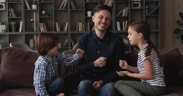 Jovem pai e filhos jogando rock-papel-tesoura em casa — Vídeo de Stock