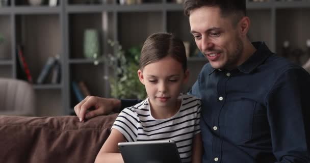 Padre e hija pequeña juegan videojuegos en la tableta — Vídeos de Stock