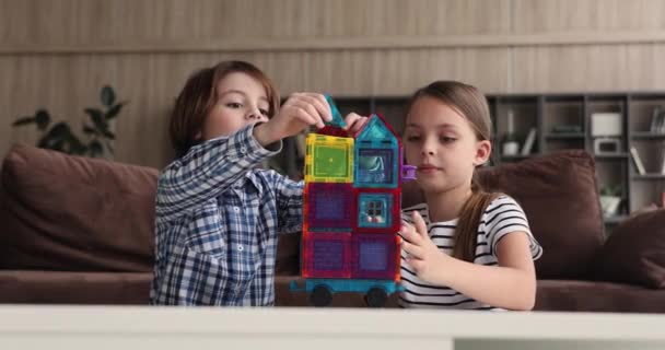 Rodzeństwo budować kreatywny pojazd z kołami grać zestaw konstrukcji magnetycznych — Wideo stockowe