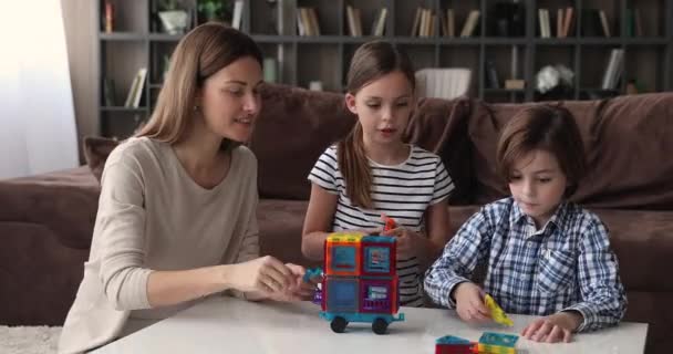 Mãe pequeno filho e filha jogar juntos conjunto de construção magnética — Vídeo de Stock