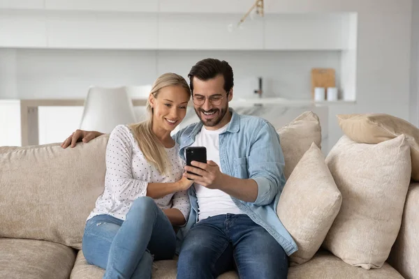 Glückliches junges Paar Mann und Frau nutzen gemeinsam Smartphone — Stockfoto