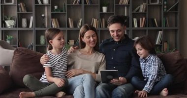 Çocuklu bir çift tablet kullanarak video oyunu oynarken eğleniyor