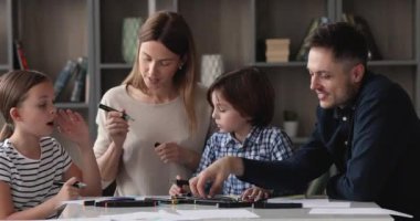 Renkli keçeli kalemlerle resim çizen tam aile