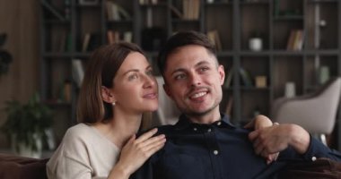 Yakından hayalperest eşler kanepeye oturur ve başka tarafa bakarlar.