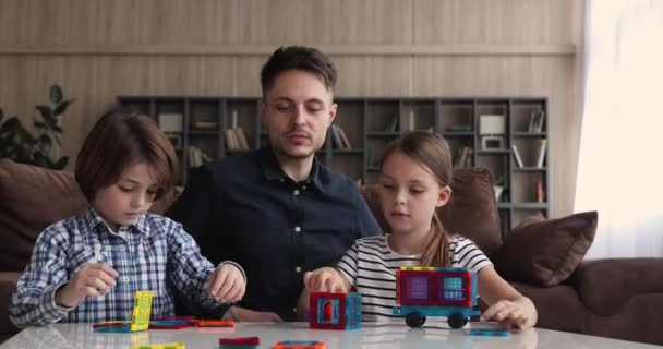 Πατέρας και παιδιά χτίζουν δημιουργικό όχημα παίζουν μαζί μαγνητικό κατασκευαστή — Αρχείο Βίντεο