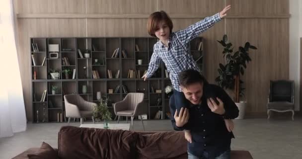 Ung aktiv pappa bär sin lilla söta son på axlarna — Stockvideo