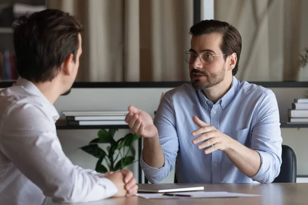 Confident manager in glasses consulting client at meeting in office — Stock Photo, Image