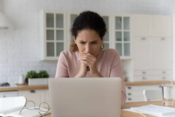 Gestresste junge Frau blickt auf Laptop-Bildschirm. — Stockfoto