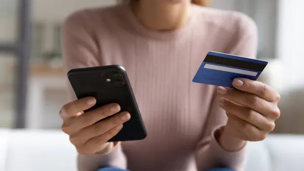Nahaufnahme einer jungen Frau mit Smartphone und Bankkarte. — Stockfoto