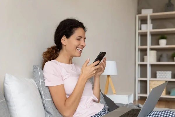 Rozptýlený od práce s počítačem mladá žena pomocí telefonu. — Stock fotografie