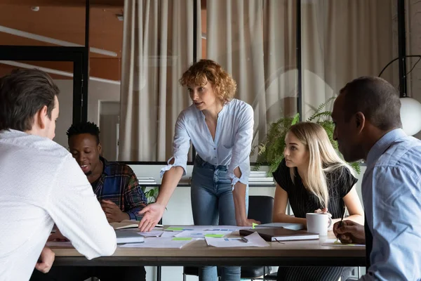 Confiada empresaria mentora explicando estrategia, dirigiendo briefing con diversos empleados — Foto de Stock