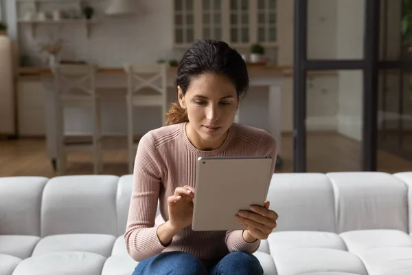 Jovem hispânica interessada usando tablet de computador digital. — Fotografia de Stock