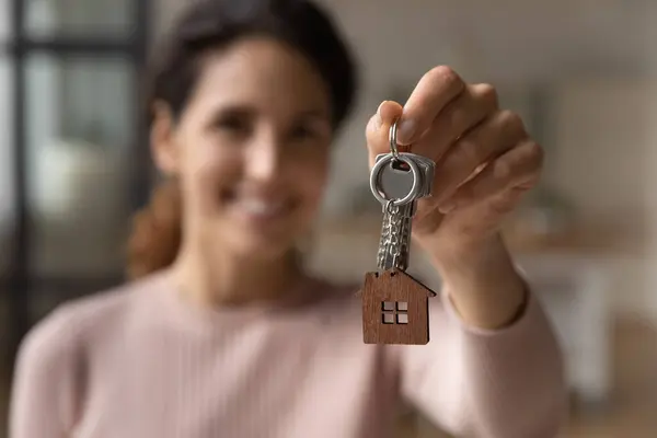 Glückliche junge Frau zeigt Schlüssel zur Kamera. — Stockfoto