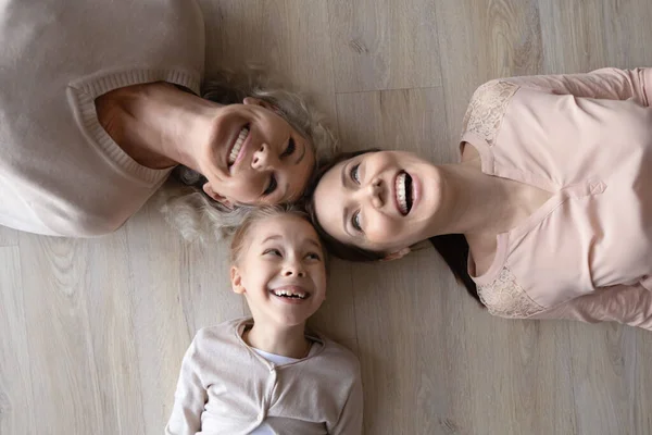 Three diverse women daughter mother grandma laughing posing on floor — Stock Photo, Image