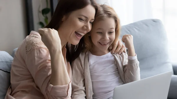 Emocionada madre e hija pequeña consiguiendo la victoria en el juego de ordenador — Foto de Stock