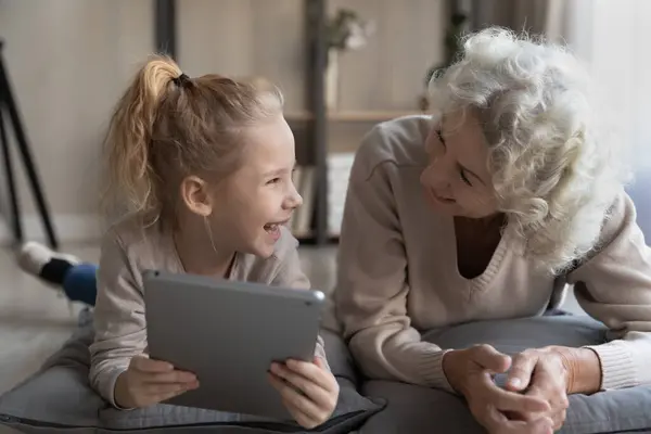 Idade babá e menina assistir vídeo no tablet digital — Fotografia de Stock