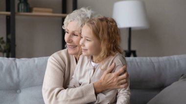 Hayalperest küçük kız, sevgi dolu yaşlı büyükannenin dizlerine otur.