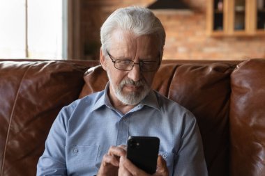 Akıllı telefonda teletıp uygulaması kullanan Odaklanmış 70 'lerin yaşlısı