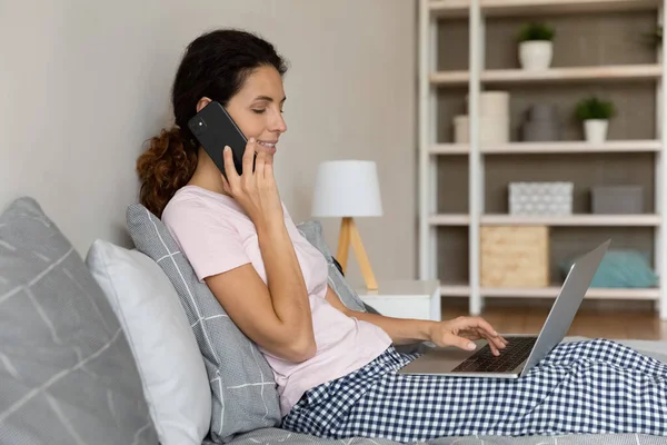 Bilgisayarda çalışırken cep telefonuyla konuşan mutlu bin yıllık kadınlar.. — Stok fotoğraf