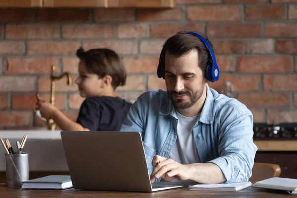 Positive freelance man in headphones working at laptop — Stock Photo, Image