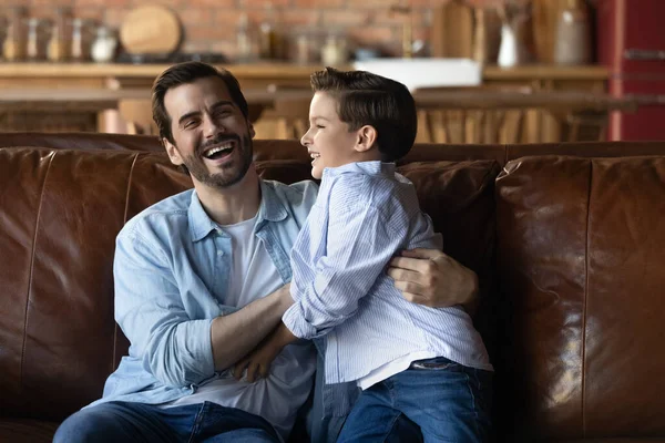 Emocionado pai e filho se divertindo em casa, curtindo a brincadeira — Fotografia de Stock