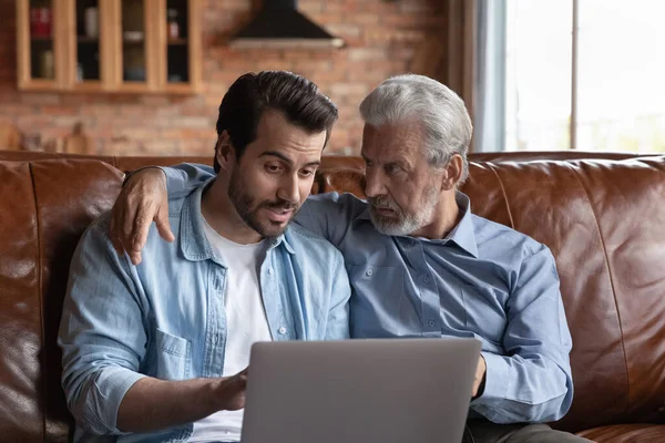 Erwachsener Sohn bringt Senior-Vater die Nutzung von Online-Apps bei — Stockfoto