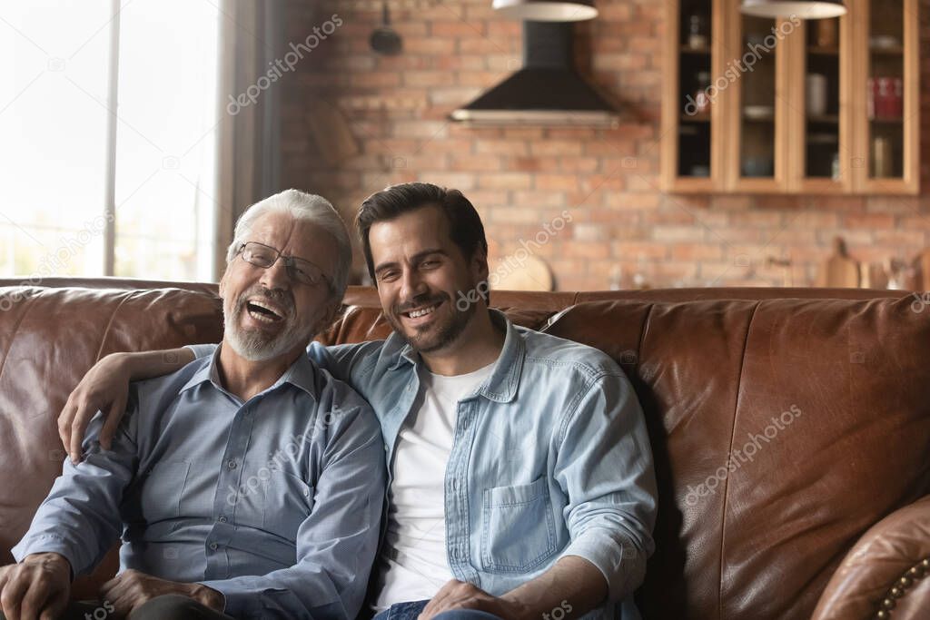 Happy grown son and older father meeting, enjoying leisure