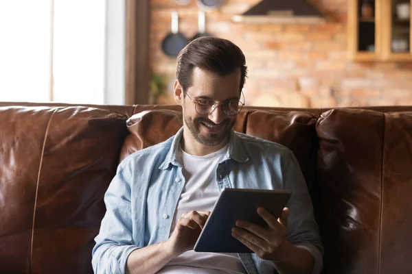 Feliz hombre milenario utilizando la aplicación en línea en la computadora tableta — Foto de Stock