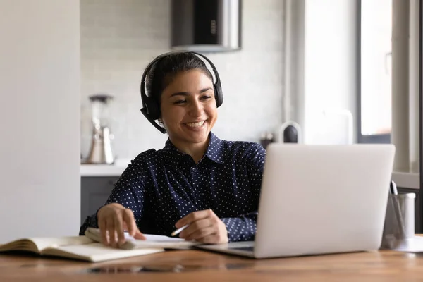 Felice studente indiano in cuffia con microfono che frequenta la formazione virtuale — Foto Stock