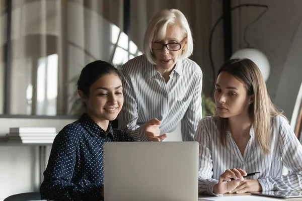 Insegnante aziendale che mostra e spiega i dati di lavoro alle studentesse — Foto Stock