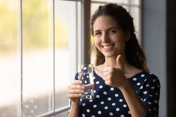 Tatlı su içen, şeffaf cam tutan mutlu İspanyol kadın. — Stok fotoğraf